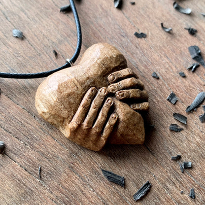 “Hands squeezing a Heart” Pendant